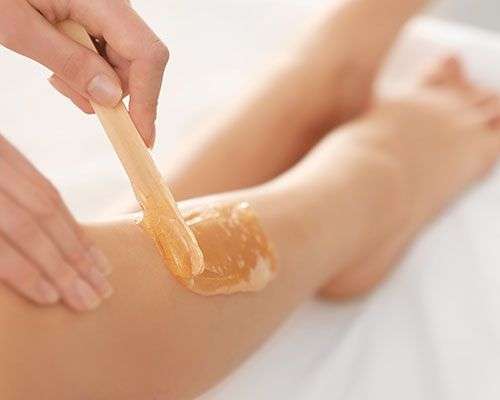 woman waxing her feet