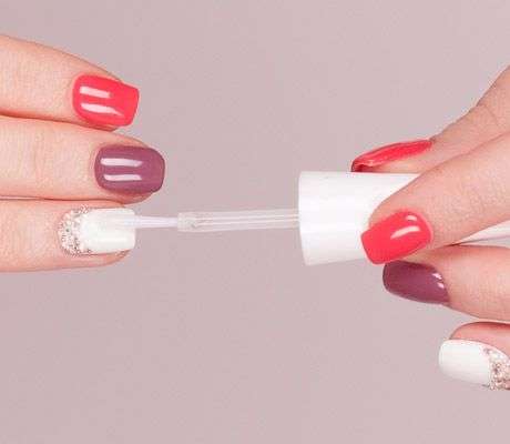 applying top coat of nail polish